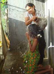 anstelle Sandamalis leiblichen Mutter, vollzieht Vinitha die rituelle Waschung im Chathura-Kinderheim 